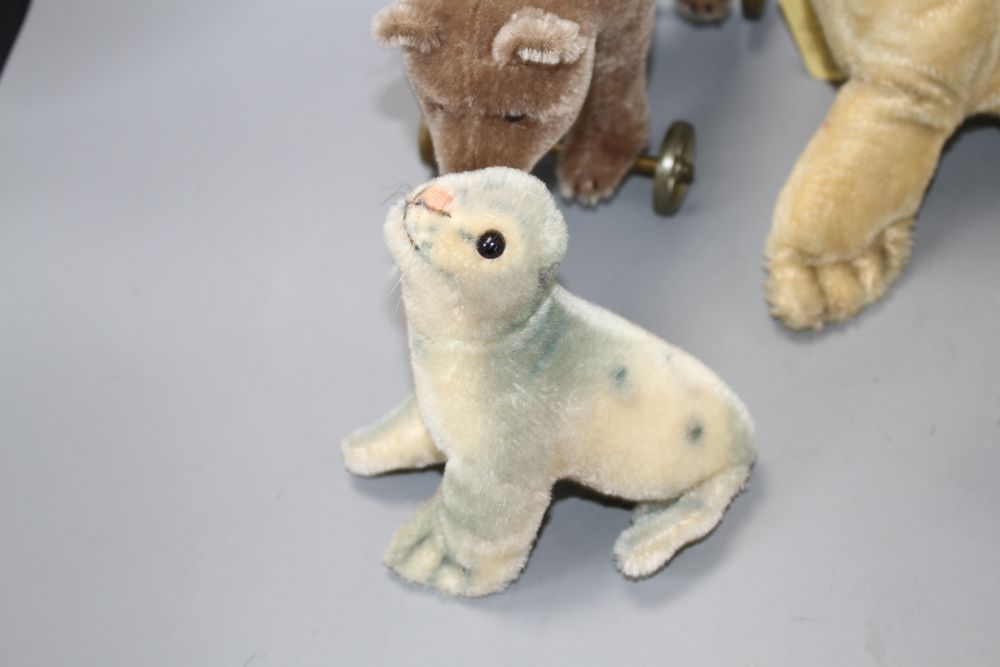 A 1960s Steiff Robby sea lion, another similar larger sea lion, a penguin, a turtle and a more recent bear on wheels
